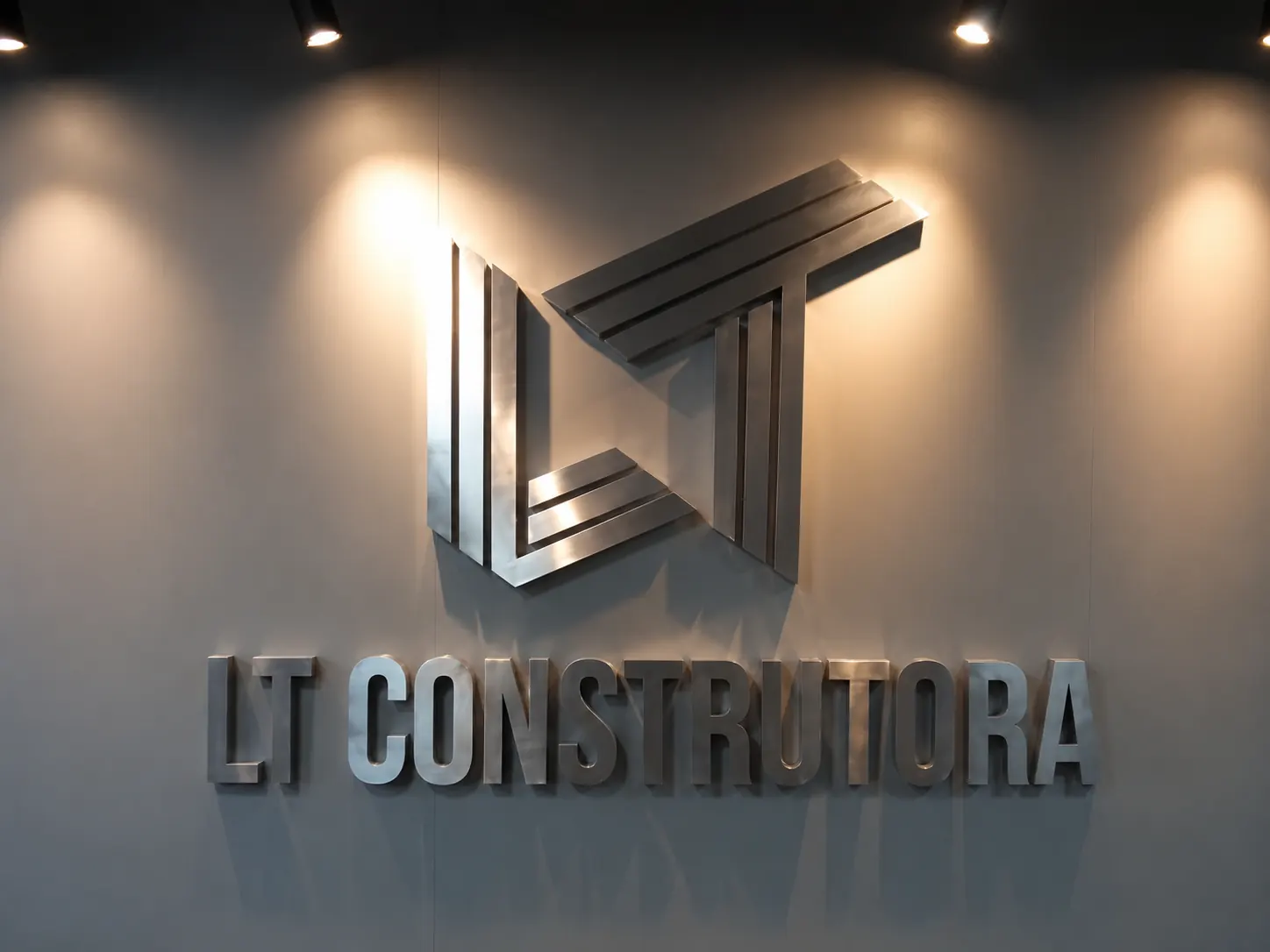 Letras caixa metálicas LT Construtora aplicadas em parede interna